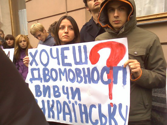 Foto de manifestantes carregando uma faixa com dizeres em ucraniano