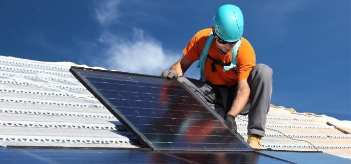 foto de um homem instalando uma placa de captao de energia solar