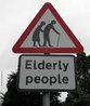  Foto de um poste com placa mostrando a representao de um casal idoso andando. Abaixo, o aviso "Pessoas idosas".   Palavras-chave: placa, trnsito, comunicao, linguagem no-verbal.
