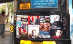 Foto de vrios anncios publicitrios veiculados na traseira de um nibus, em Singapura. Veem-se propagandas de filmes e programas de TV aberta. Palavras-chave: ponto de nibus, transporte, rua, televiso.