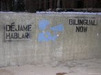 Foto de uma pichao em muro com dizeres em espanhol e ingls "Deixem-me falar" e "Bilingue j", respectivamente.  Palavras-chave: manifestao, lei, direitos. 