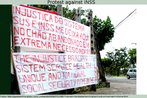 Foto da faixa produzida por um homem em protesto contra um rgo de sade. Leem-se as mensagens em portugus e ingls.  Palavras-chave: Indignao. Povo. Sade pblico. Direito. Lei.