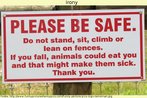 Foto de uma placa com o dizer: "Por favor, cuidado. No se recoste, sente, suba ou apoie na cerca. Se voc cair, os animais vo comer voc e isso far com que eles passem mal. Obrigado".  Palavras-chave: Ironia. Segurana. Cuidado. Preveno. Aviso.