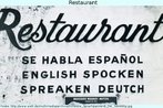 Detalhe da fachada de um restaurante, em que se l "Fala-se... (espanhol, ingls, alemo, respectivamente)", nas trs lnguas. Na expresso em ingls e em alemo, observam-se problemas de escrita. Palavras-chave: Idiomas. Comrcio. Ortografia. Verbos. Particpio.