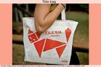 Foto de uma moa carregando uma bolsa do tipo "tote bag", com estampa de origami em forma de gato e a inscrio "Hello" (em japons e ingls). Palavras-chave: Tiracolo. Moda. Greeting. Saudao.