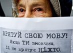 Foto de uma idosa segurando um cartaz escrito em lngua ucraniana.  Palavras-chave: jornal, vocabulrio, idosa, leitura