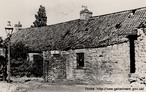 Foto antiga, em preto e branco, de uma casa velha de tijolos e telhas. Palavras-chave: casa, moradia, descrição, gêneros textuais, pobreza, desenvolvimento.