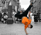 foto de um rapaz danando street dance. Veem-se ao fundo vrios espectadores - estes em preto-e-branco.  Palavras-chave: cores, arte, rua, dana, movimento, jovens.