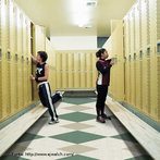 Foto de duas meninas guardando materiais em seus armários escolares individuais, num vestiário. Os school lockers são comuns em escolas dos Estados Unidos e outros países.  Palavras-chave: escola, escaninho, cacifo, organizador. 