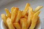 Foto de uma pequena porção de batatas-fritas. Leem-se os nomes "Chips", referente ao nome do prato em inglês britânico, e "French friyes", expressão utilizada nos Estados Unidos.  Palavras-chave: variação linguística, Inglaterra, alimentação, junk food.