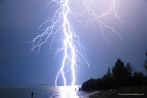 Fotografia de um raio prximo a uma praia,  noite.  Palavras-chave: natureza, descrio, campo semntico, descarga, eletricidade, chuva, literatura, relmpago, raio.