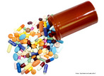 Foto de um frasco de remédio deitado, com inúmeros tipos de cápsulas e comprimidos, de cores diferentes.  Palavras-chave: remédios, medicação, interpretação, interdiscurso. 