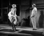Tradicional foto de Marilyn Monroe, atriz norte-americana de vestido branco, em pé sobre uma saída de ar.  Palavras-chave: Marilyn, EUA, vestido, celebridade, interdiscurso, descrição.