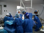 Foto de uma equipe médica em procedimento cirúrgico, com vários equipamentos da área.  Palavras-chave: saúde, medicina, cirurgia, descrição, interpretação, narrativa. 