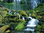 Foto de uma cachoeira em um ambiente de floresta, com muitas pedras cobertas de limo.  Palavras-chave: cachoeira, geologia, água.