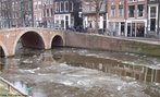  Foto de um dos canais centrais da capital da Holanda, em um dia de inverno. Veem-se placas de gelo sobre a gua. Em segundo plano, podem-se observar as bicicletas, caractersticas da cidade, e os casarios dos sculos XVI e XVII, transformados em lojas.  Palavras-chave: Amsterd, rio, frio, ponte, cidade, turismo, transculturalidade.