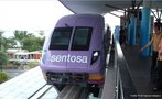 Foto do trem expresso que conduz à ilha de Sentosa, Singapura. Na imagem, veem-se passageiros na plataforma suspensa, prestes a entrar no veículo.  Palavras-chave: transporte, trem, metrô, turismo.
