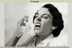 Foto em preto e branco de uma mulher espirrando, tendo em frente ao rosto um lenço. Palavras-chave: Vírus. Gripe. Prevenção. Saúde. Ação. Descrição. To sneeze.