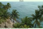 Foto de uma área de areia e palmeiras, numa praia da ilha de Sentosa, em Singapura. Nota-se também a contenção das ondas feitas artificialmente, com pedras. Palavras-chave: Arquitetura. Artificial. Natural. Vegetação. Ásia. Cultura.