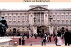 Foto da fachada do Palácio de Buckingham, residência oficial da família real britânica. Veem-se vários transeuntes e uma estátua. Palavras-chave: Turista. Inglaterra. Praça. Monarquia.