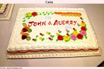 Foto de um bolo decorado, com dois nomes sobre a cobertura. Palavras-chave: Doce. Festa. Nome. Culinária. Interpretação. Descrição.