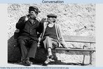 Nesta foto, dois homens de idade conversam - um escuta e o outro fala, gesticulando. Palavras-chave: Gesto. Linguagem. Comunicação. Velho. Idoso.